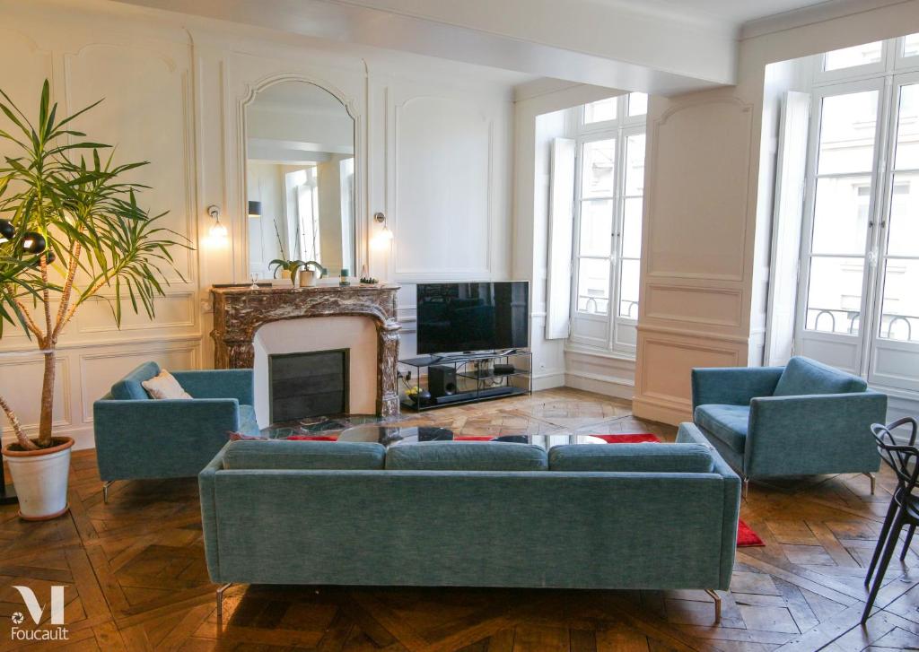 salon z niebieskimi kanapami i kominkiem w obiekcie Appartement design au coeur de Rennes w mieście Rennes