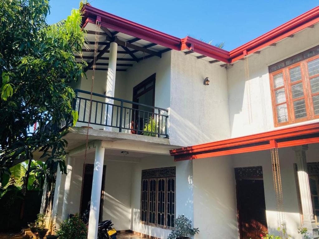 una grande casa bianca con balcone di Sensitha Holiday home a Anuradhapura