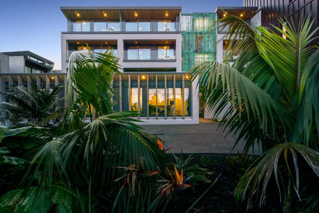 un edificio con palmeras delante en FERNZ Motel & Apartments Birkenhead en Auckland