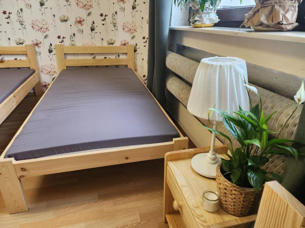 een kleine kamer met een bed en een tafel met een lamp bij Wsi spokojna...Jura in Siamoszyce