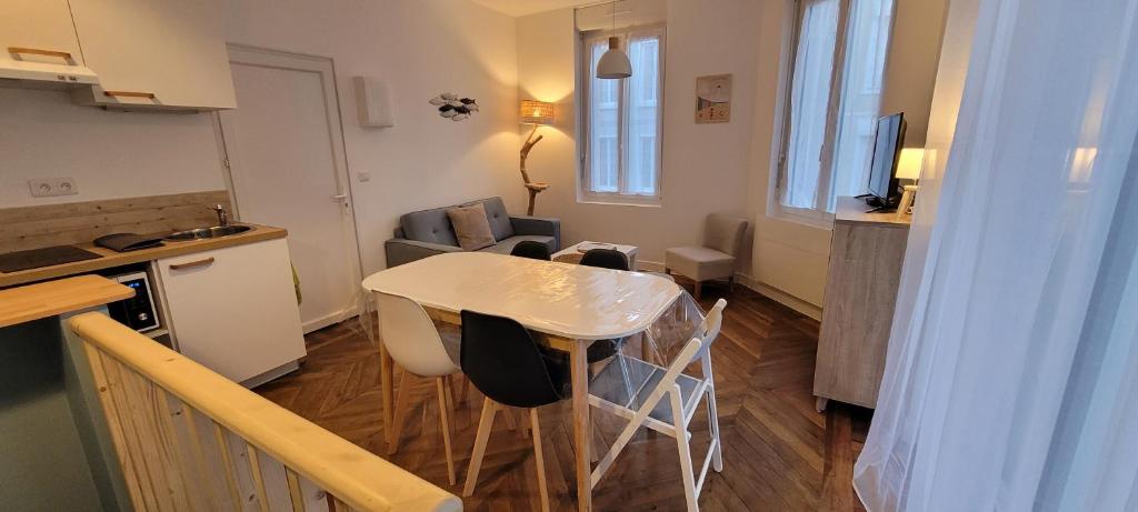 een keuken en een woonkamer met een tafel en stoelen bij Appartement 5 personnes à 100 m de la plage in Berck-sur-Mer