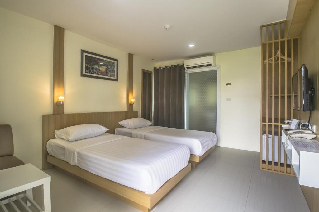 Postel nebo postele na pokoji v ubytování Petchsiri Boutique Hotel เพชรสิริ บูทิค
