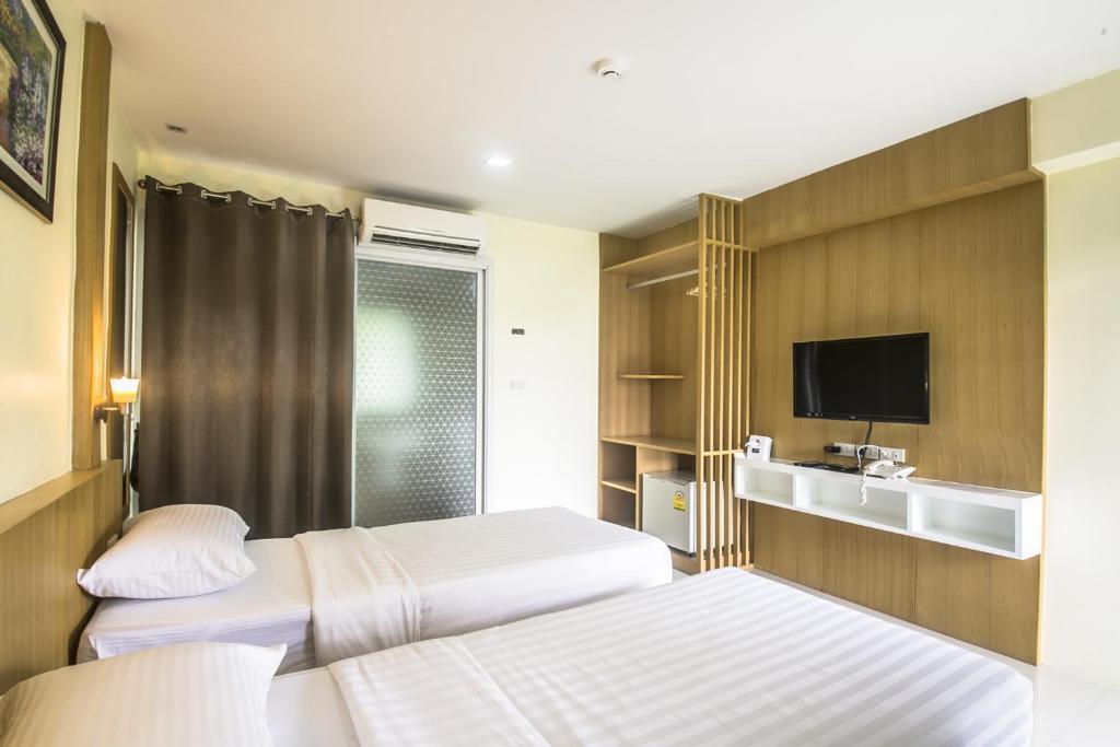 Postel nebo postele na pokoji v ubytování Petchsiri Boutique Hotel เพชรสิริ บูทิค
