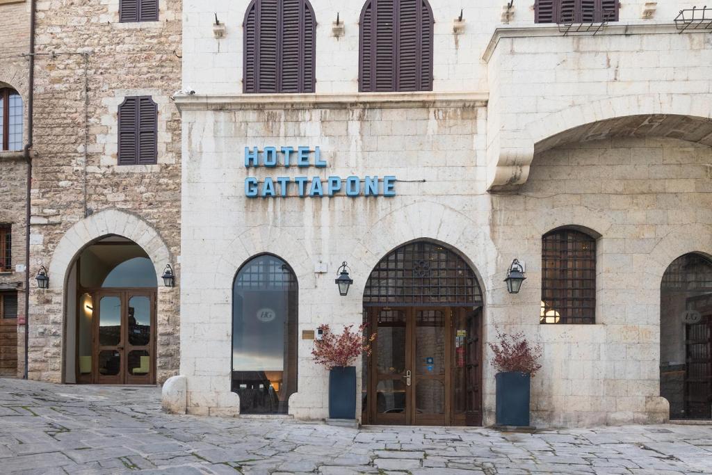 un bâtiment avec un panneau d'un hôtel sacrifiant dans l'établissement Hotel Gattapone, à Gubbio