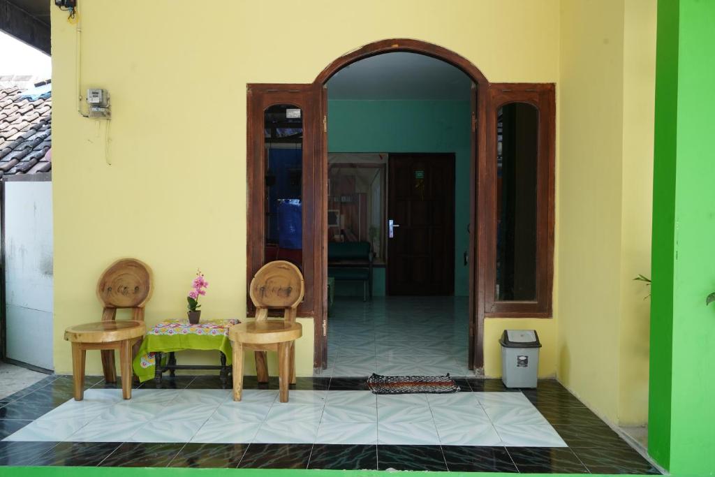 a room with a table and two chairs and a mirror at Omah Bogem Homestay Syariah in Randugunting
