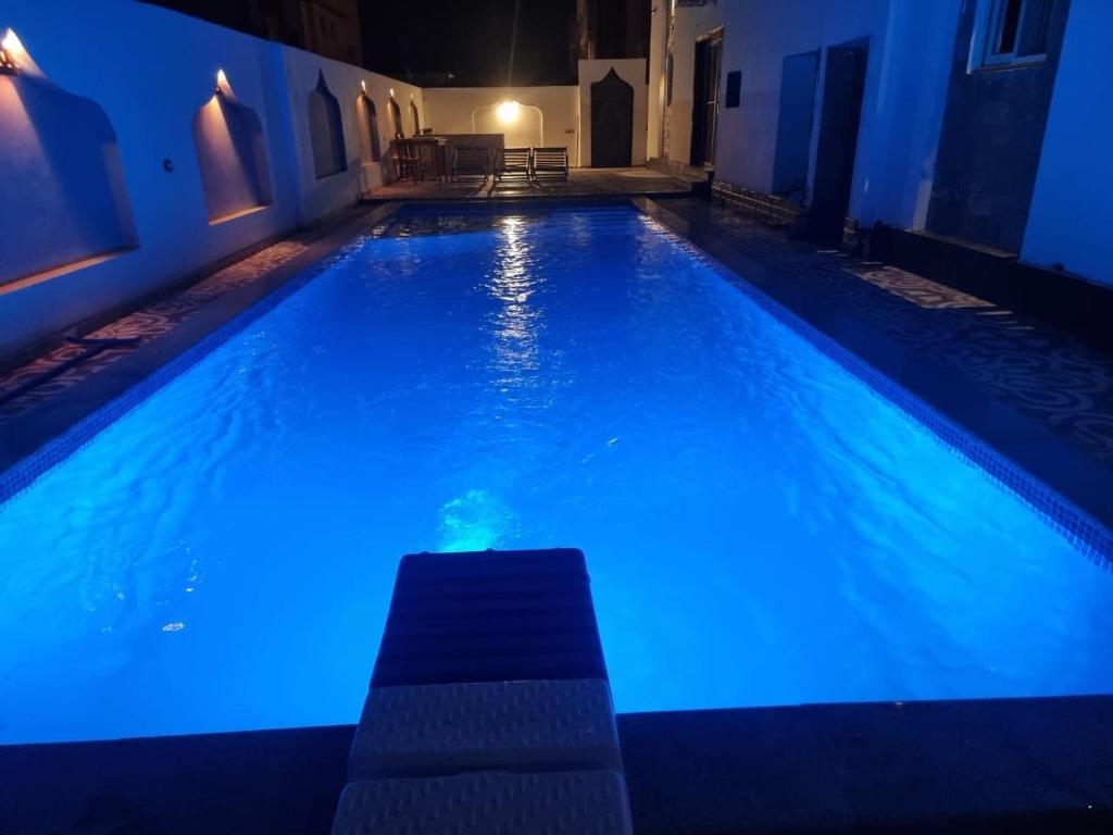 - une piscine avec des lumières bleues dans une maison dans l'établissement Arbian Valla, à Dahab