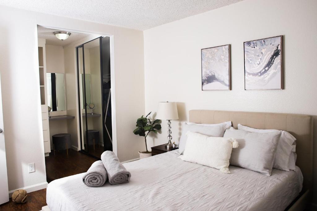 a bedroom with a bed with white sheets and pillows at Homey Oasis within minutes of San Diego adventures in San Diego