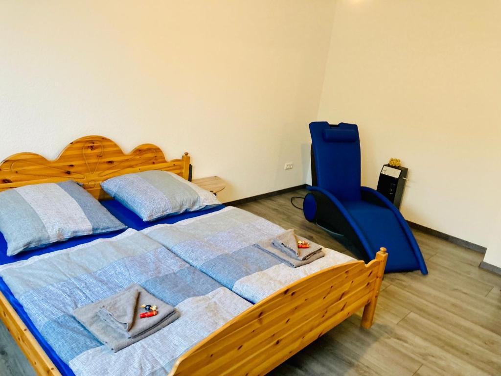 a bedroom with a wooden bed and a blue chair at Sauna-Schmied in Weißenfels