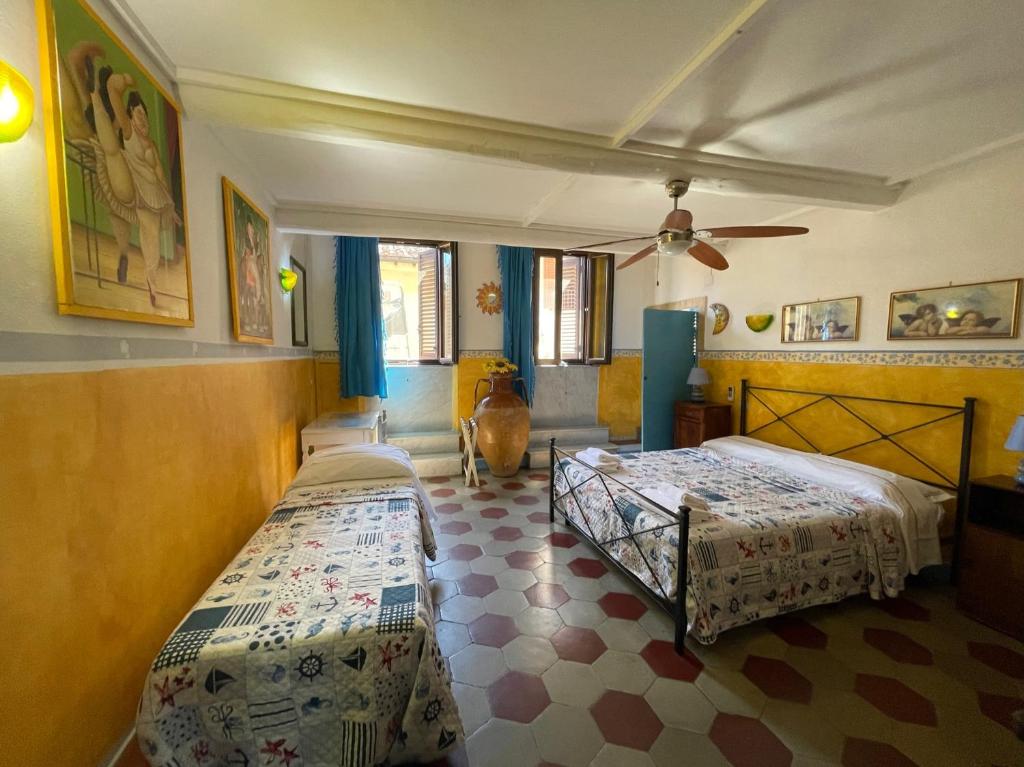 a bedroom with two beds and a ceiling fan at B&B Tony and Judy in Orbetello