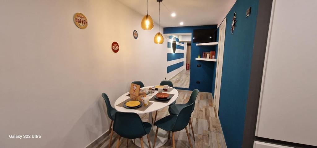 una sala da pranzo con tavolo e sedie bianchi di Blumon guest House a Napoli