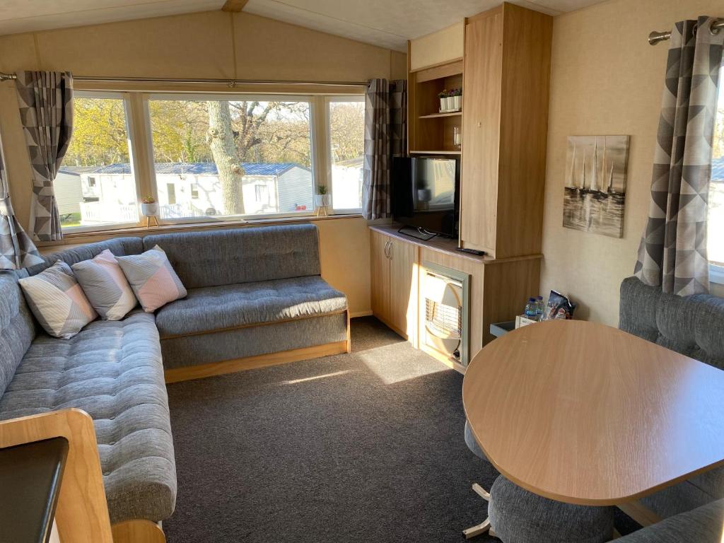 Porchfield的住宿－14 Greenwood Thorness Bay，客厅配有沙发和桌子