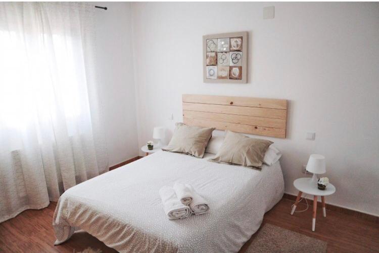 Un dormitorio blanco con una cama con toallas. en Aire de valsain, en La Pradera de Navalhorno