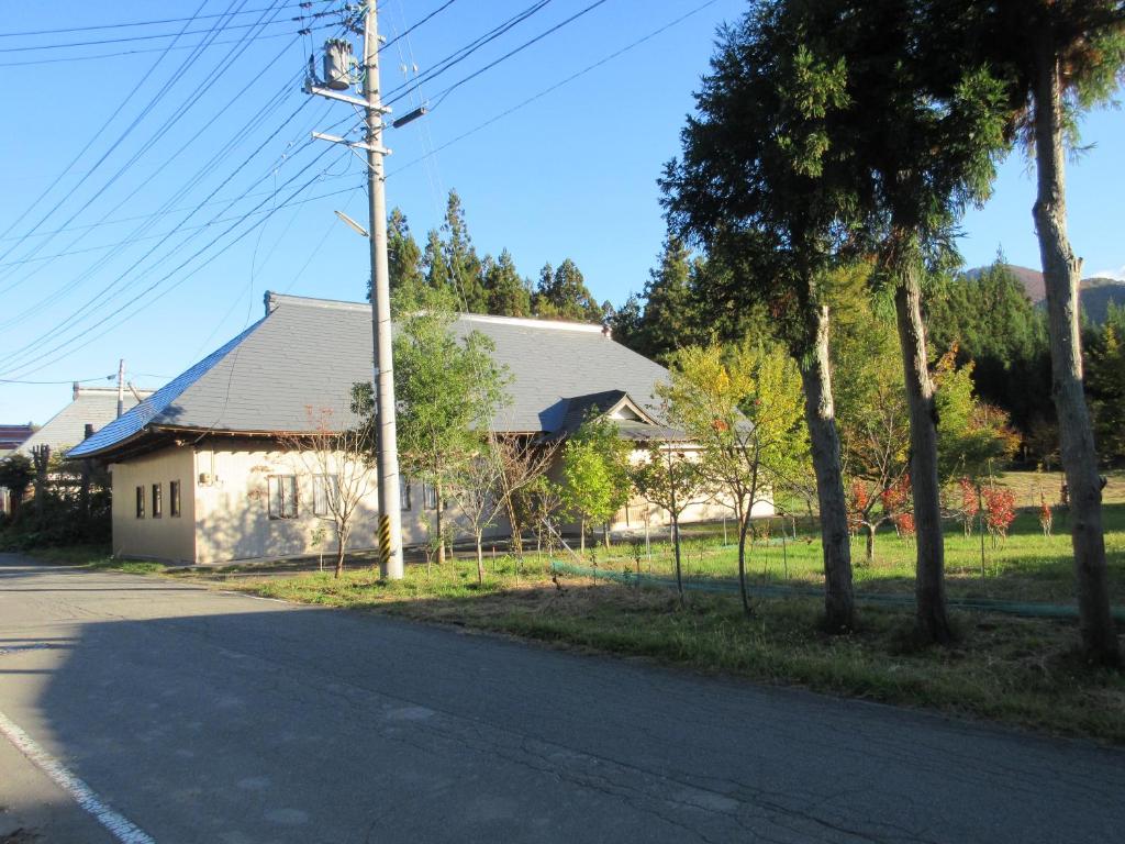 une maison sur le côté d'une route dans l'établissement 民泊くま - 絵画と音楽の宿, à Inawashiro