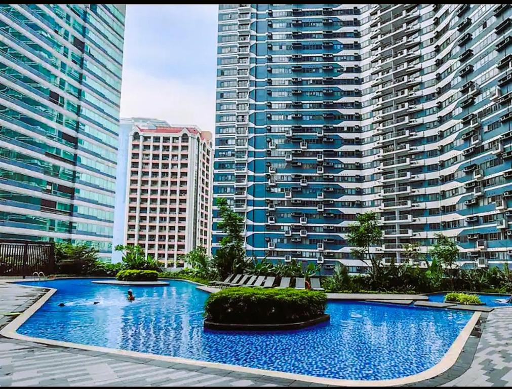 a large swimming pool in front of tall buildings at Air Residences Condominium Deluxe in Manila