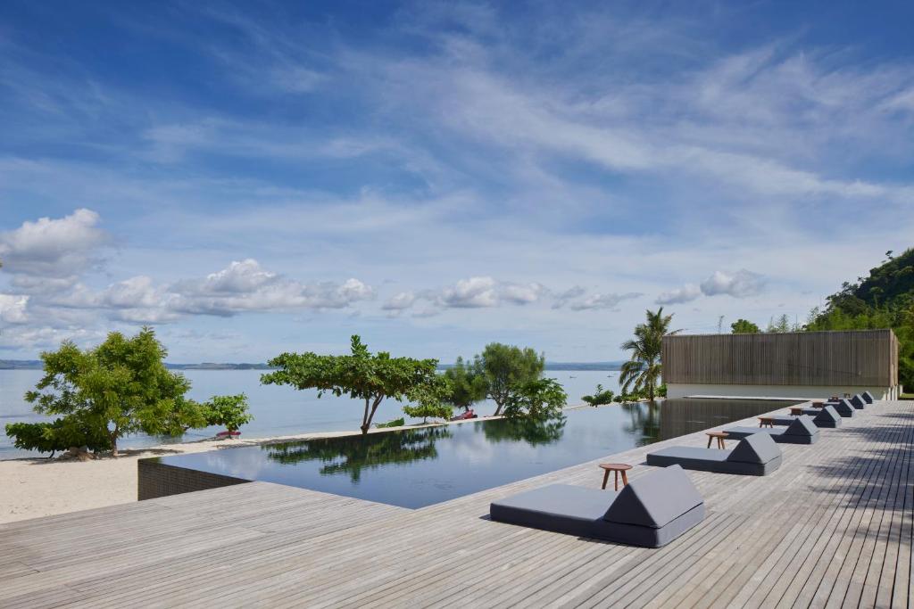 un complexe avec une piscine et une vue sur l'océan dans l'établissement Innit Lombok, à Ekas