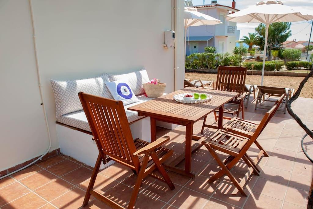 a wooden table and chairs on a patio at Villa Calliope Lardos in Lartos