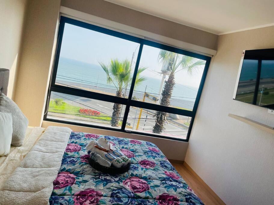 1 dormitorio con 1 cama y vistas al océano en Departamento Nuevo con piscina frente al mar, en Lima