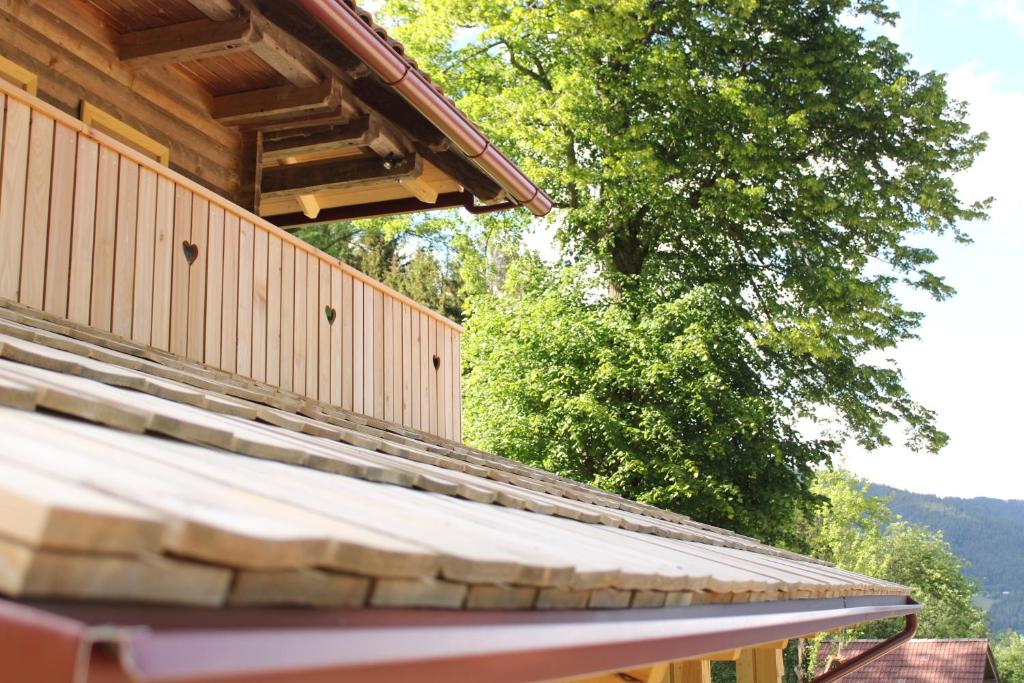 una casa de madera con techo y un árbol en el fondo en APARTMA BREST, en Gornji Grad