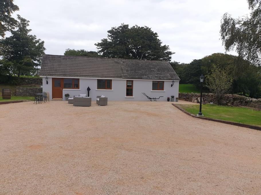 ein weißes Haus mit einer großen Einfahrt davor in der Unterkunft St Patrick's Cottage in Saul