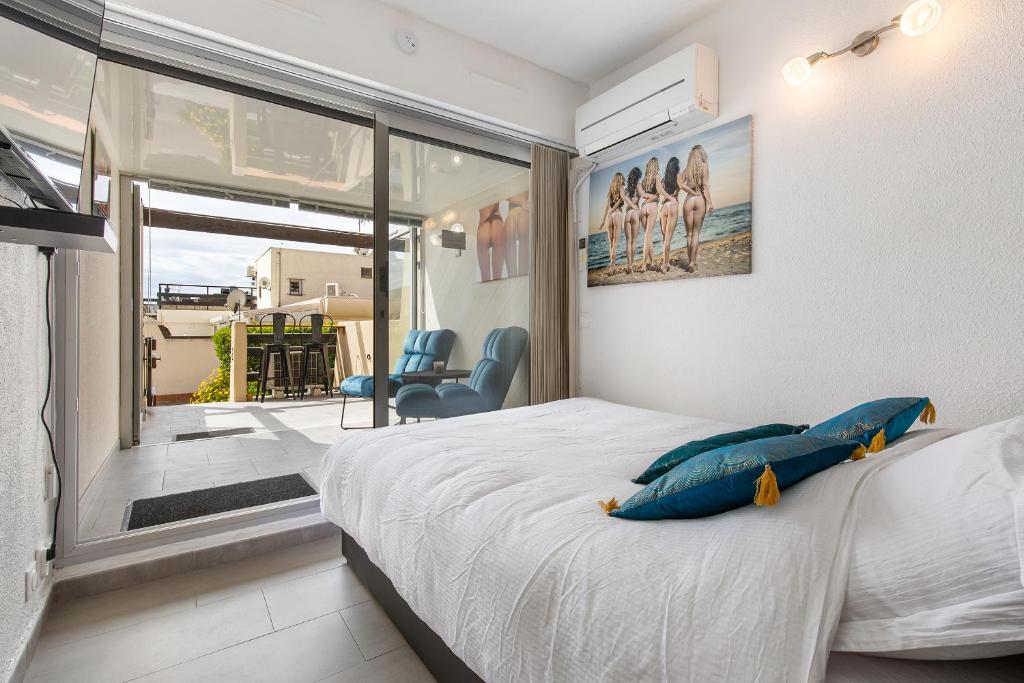 - une chambre avec un lit doté d'oreillers bleus et d'une fenêtre dans l'établissement CAP AGDE NATURISTE STUDIO PORT NATURE 3, au Cap d'Agde