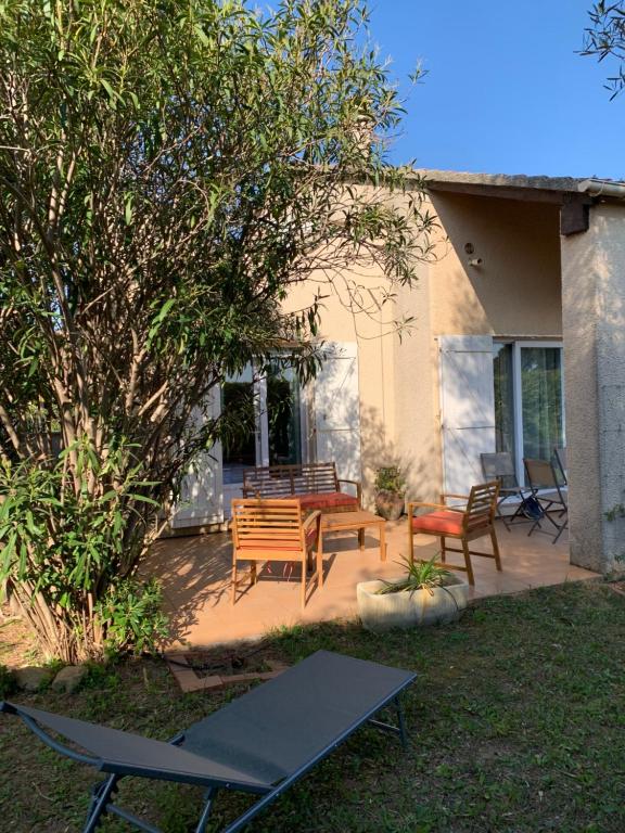 un patio avec deux bancs, une table et des chaises dans l'établissement VILLA Bord de Mer, à Cervione