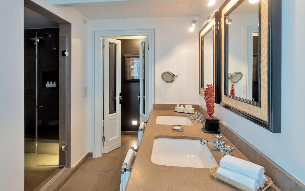 a bathroom with two sinks and a large mirror at Capri Tiberio Palace - The Leading Hotels of the World in Capri