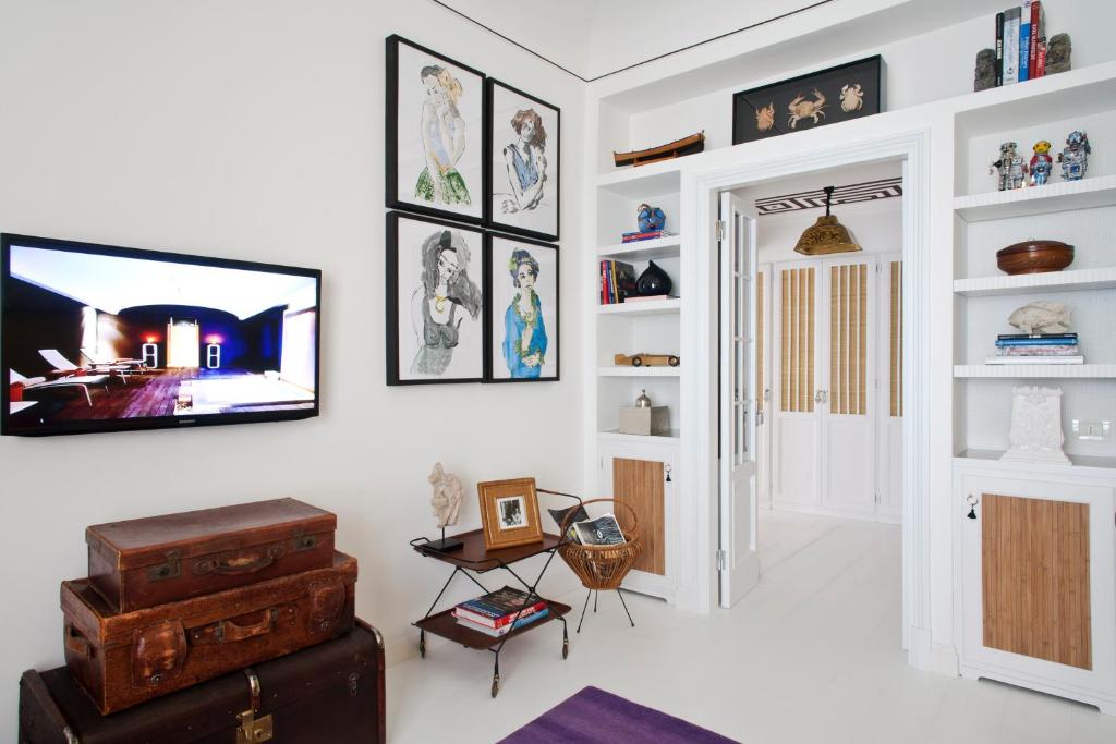 a living room with a flat screen tv on a wall at Capri Tiberio Palace - The Leading Hotels of the World in Capri