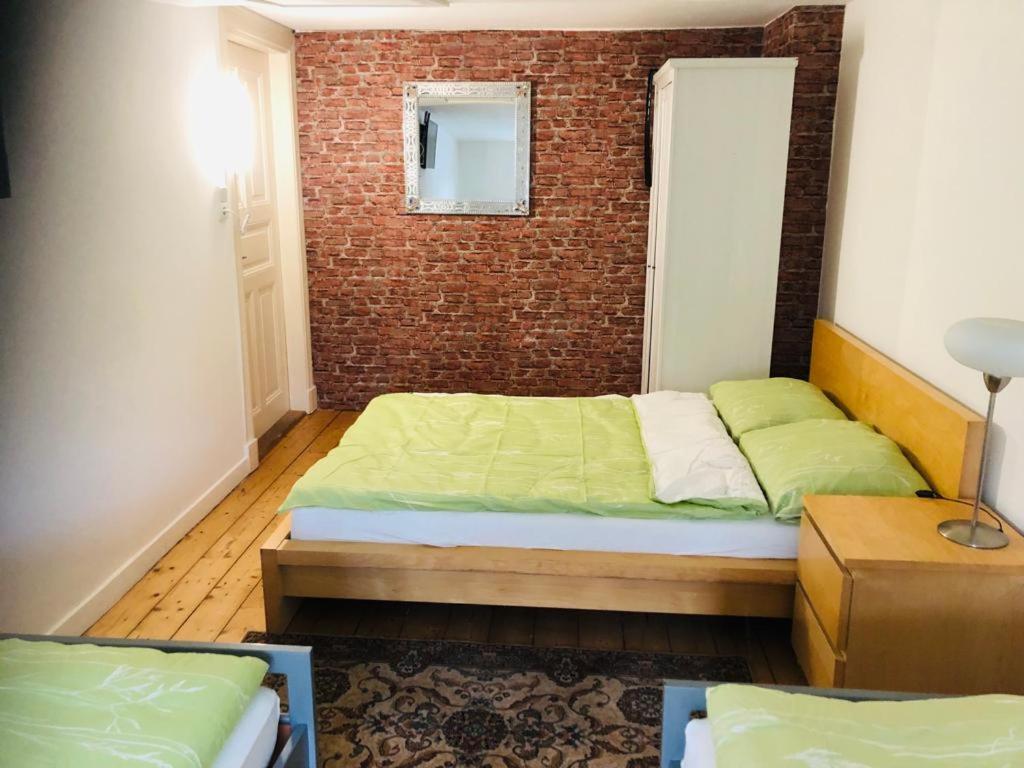 a bedroom with a bed and a brick wall at My easy home in Hamburg