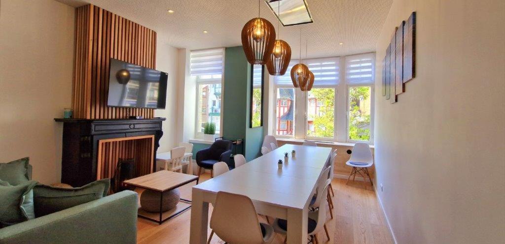 un salon avec une table et une cheminée dans l'établissement Le Petit Nord, à La Panne