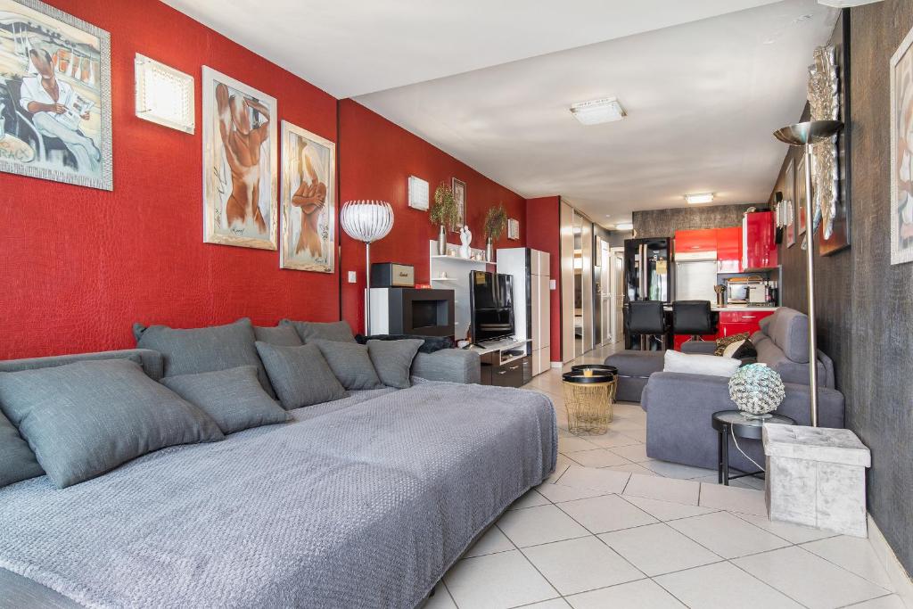 salon z kanapą i czerwoną ścianą w obiekcie appartement village naturiste port ambonne w Cap d'Agde