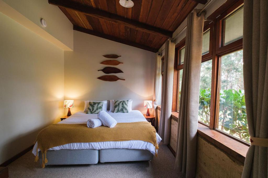 ein Schlafzimmer mit einem Bett in einem Zimmer mit Fenstern in der Unterkunft The Floating Forest in Denmark