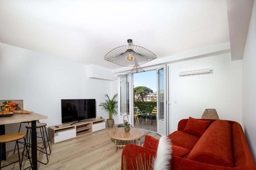 a living room with a red couch and a table at Superbe T2 Juan Les Pins 300m des plages in Antibes