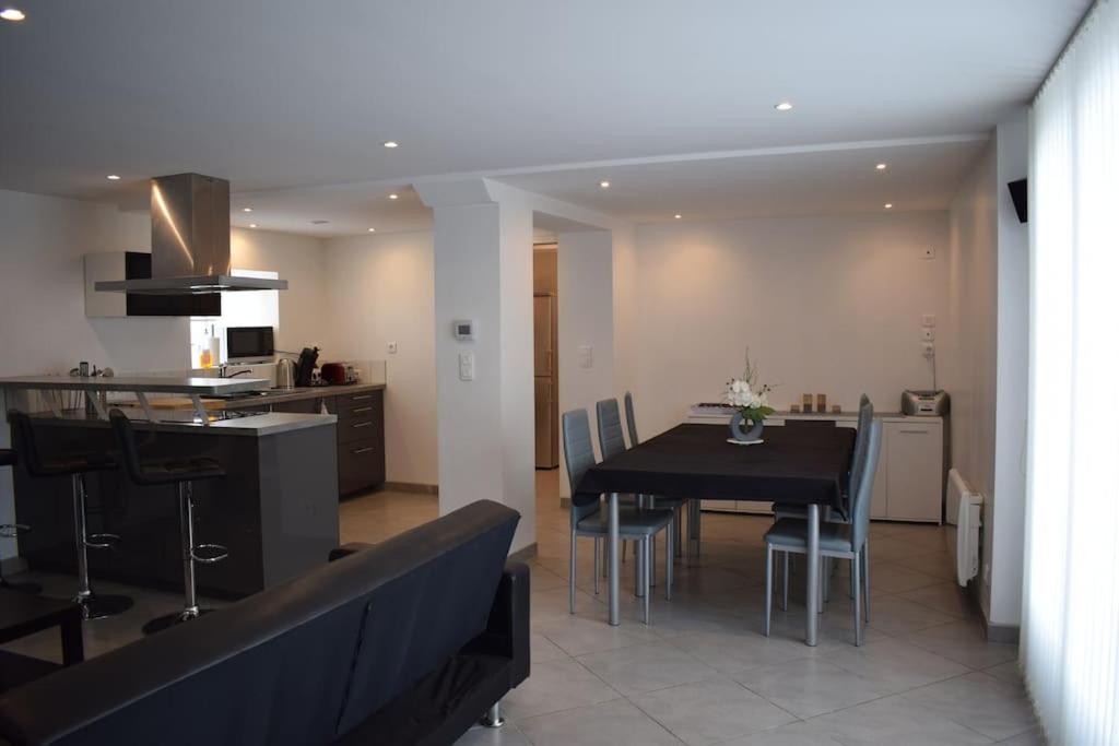 a dining room and kitchen with a table and chairs at Maison mitoyenne tout confort et parking securise. in Juillan