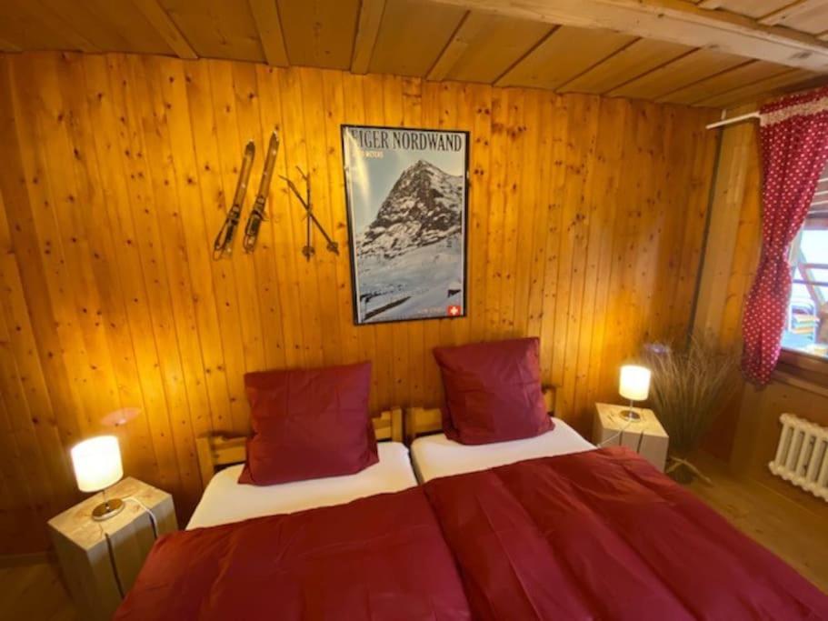 um quarto com uma cama numa parede de madeira em Wohnen mit Blick auf Eiger - ehemaliges Bauernhaus - 2 Schlafzimmer em Schwarzenburg
