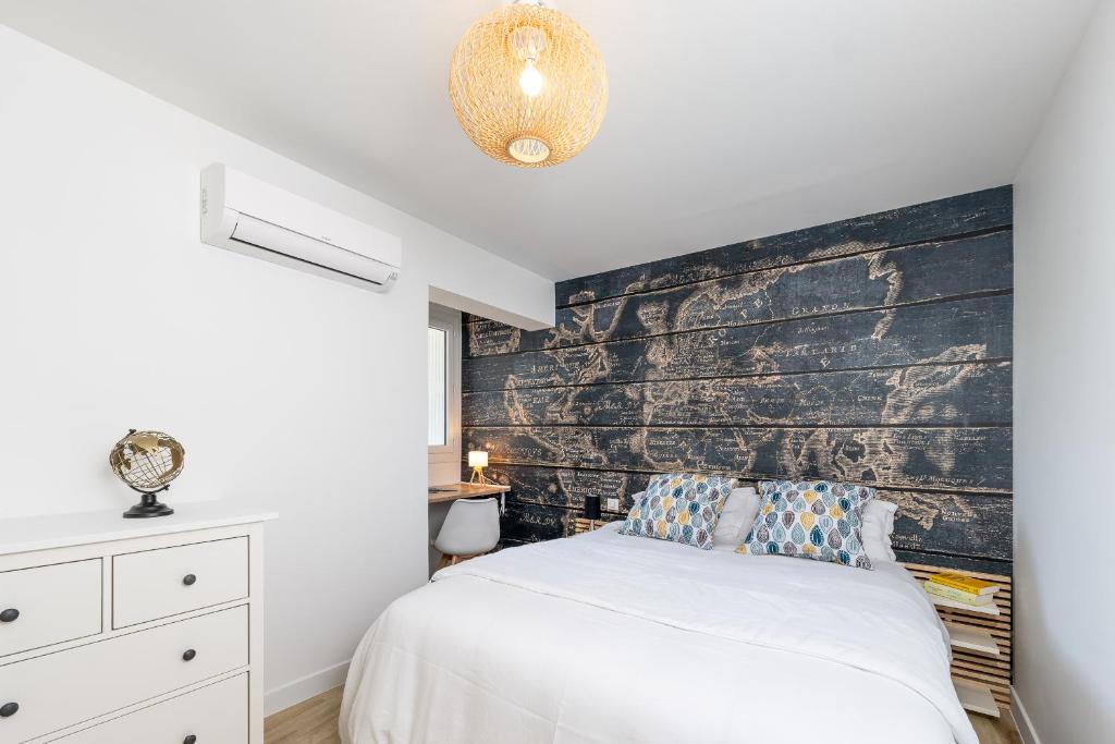 a bedroom with a white bed and a wooden wall at Superbe T2 Juan Les Pins 300m des plages in Antibes