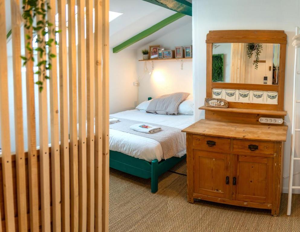Dormitorio pequeño con cama y espejo en SURF HOSTEL BIARRITZ, en Biarritz