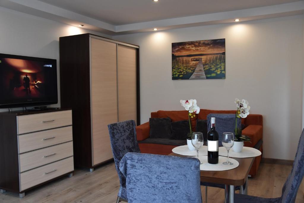 salon ze stołem i telewizorem w obiekcie Apartament Centrum - Aleja Świętego Jana Pawła II w Kołobrzegu