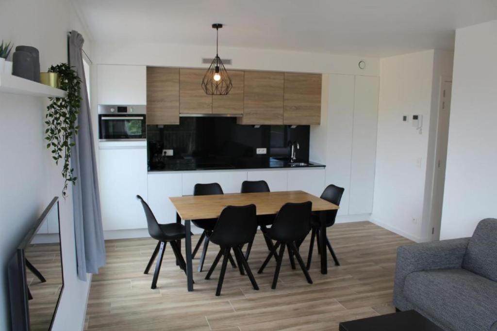 een keuken en eetkamer met een tafel en stoelen bij West Bay Familieappartement in Middelkerke