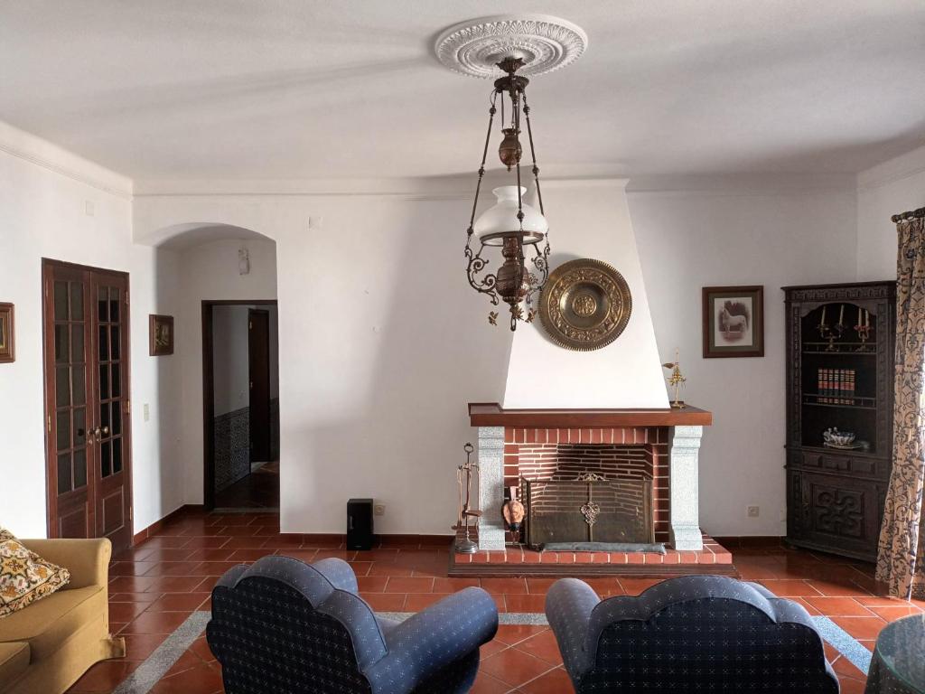 a living room with a fireplace and a chandelier at Casa Morais Pinto in Reguengos de Monsaraz