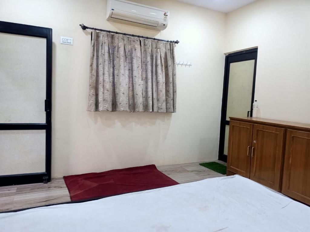 a bedroom with a white bed and a window at Patel's Home in Bhuj