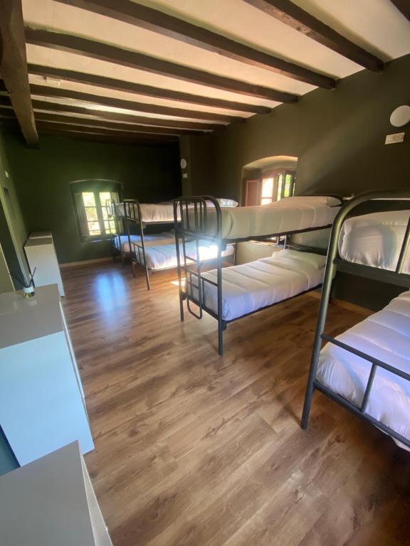 Habitación con 3 literas y suelo de madera. en Albergue de Arrojo, en Bárzana