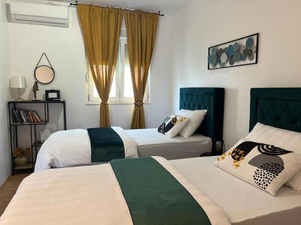 een slaapkamer met 2 bedden en 2 ramen bij Matic Apartments in Split
