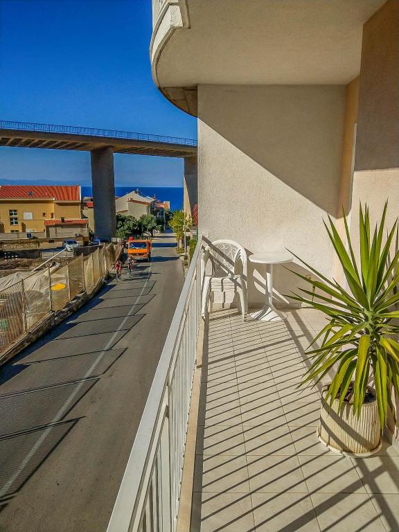 a balcony with a plant on the side of a building at Keran 2+2 in Podgora