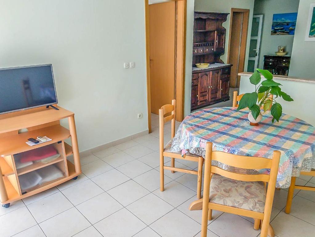 ein Esszimmer mit einem Tisch und einem TV in der Unterkunft Keran 2+2 in Podgora
