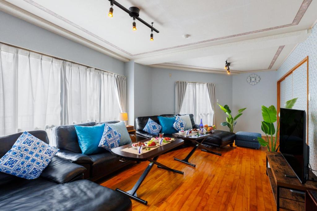 a living room with a couch and a table at Naha Gajumaru Apartment Hotel 401 in Naha