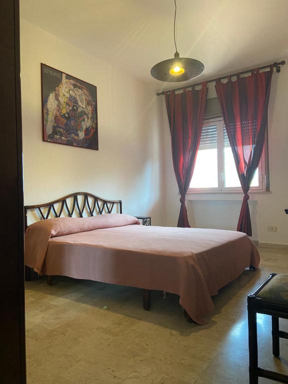 um quarto com uma cama com cortinas vermelhas e uma janela em Appartamento Addaura/Mondello em Palermo