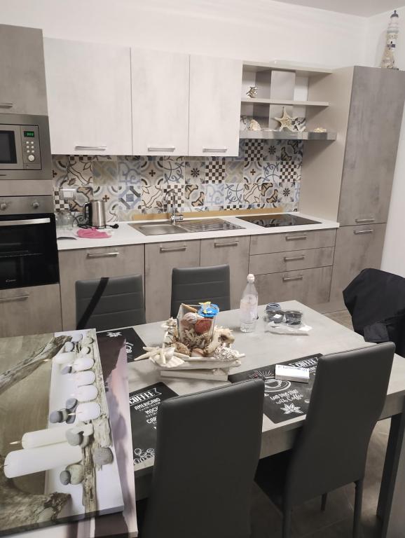 a kitchen with a table with chairs and a counter top at Villaggio al mare in Manfredonia