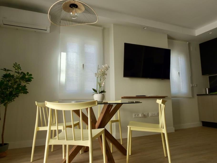 a dining room with a table and chairs and a television at La Villa de Jaén - Catedral in Jaén