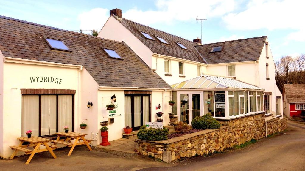 a building with a picnic table in front of it at Ivybridge Guesthouse in Fishguard