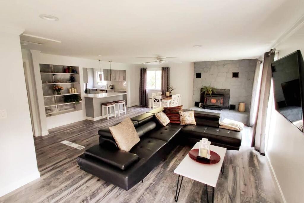 a living room with a black couch and a table at Door County Cottage, near Haines Beach! in Sturgeon Bay
